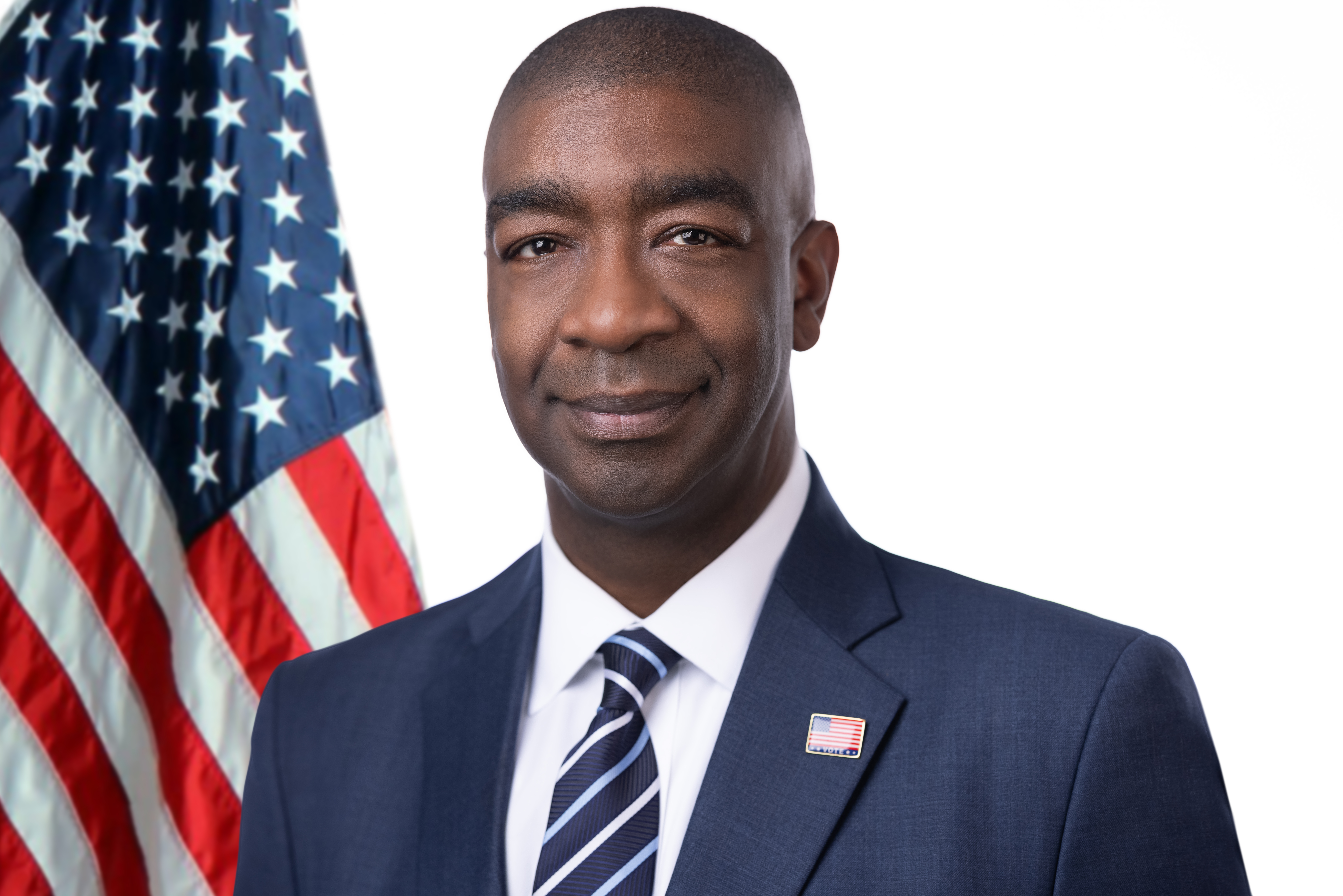 Commissioner Tom Hicks next to an American Flag