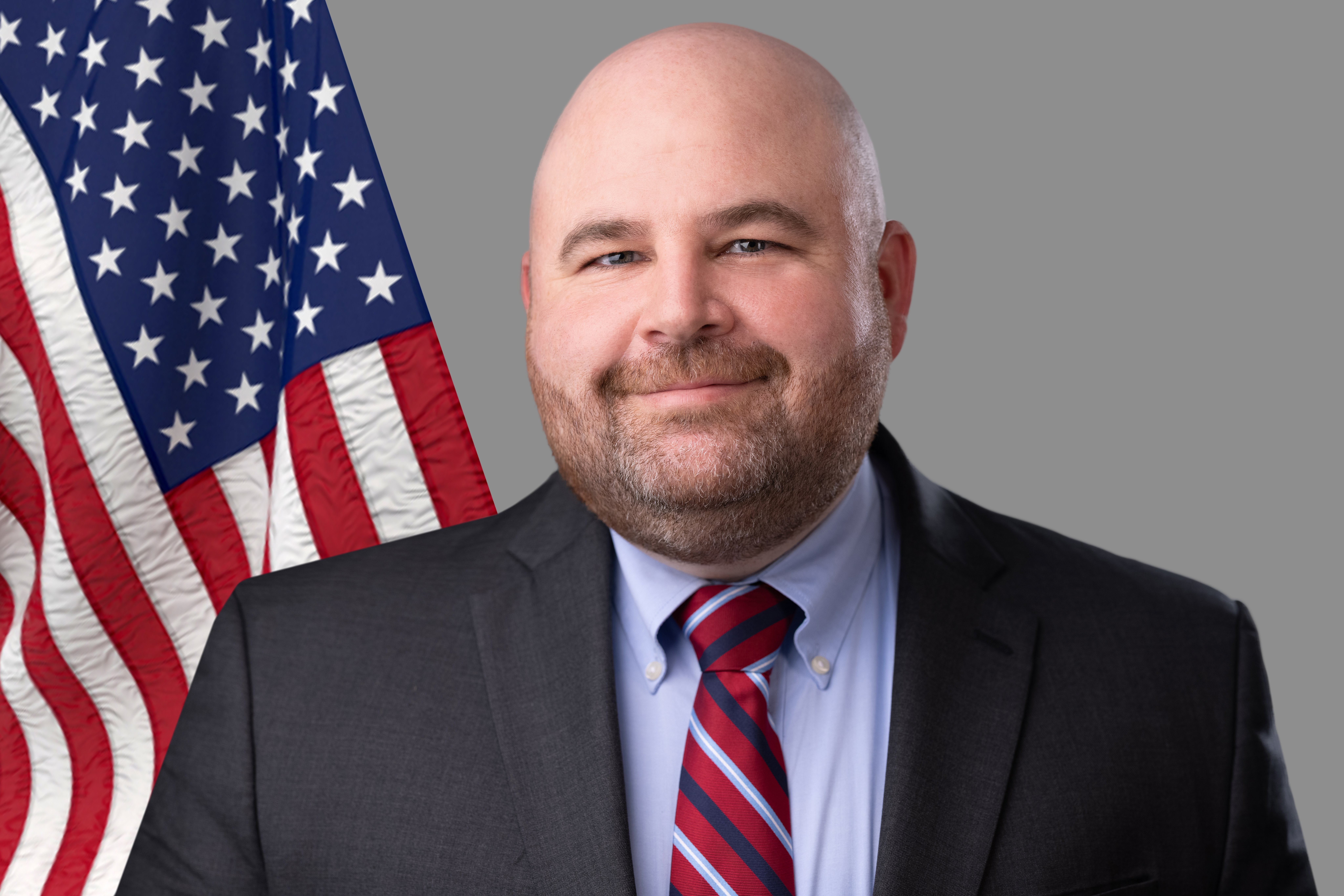 Commissioner Ben Hovland next to an American flag