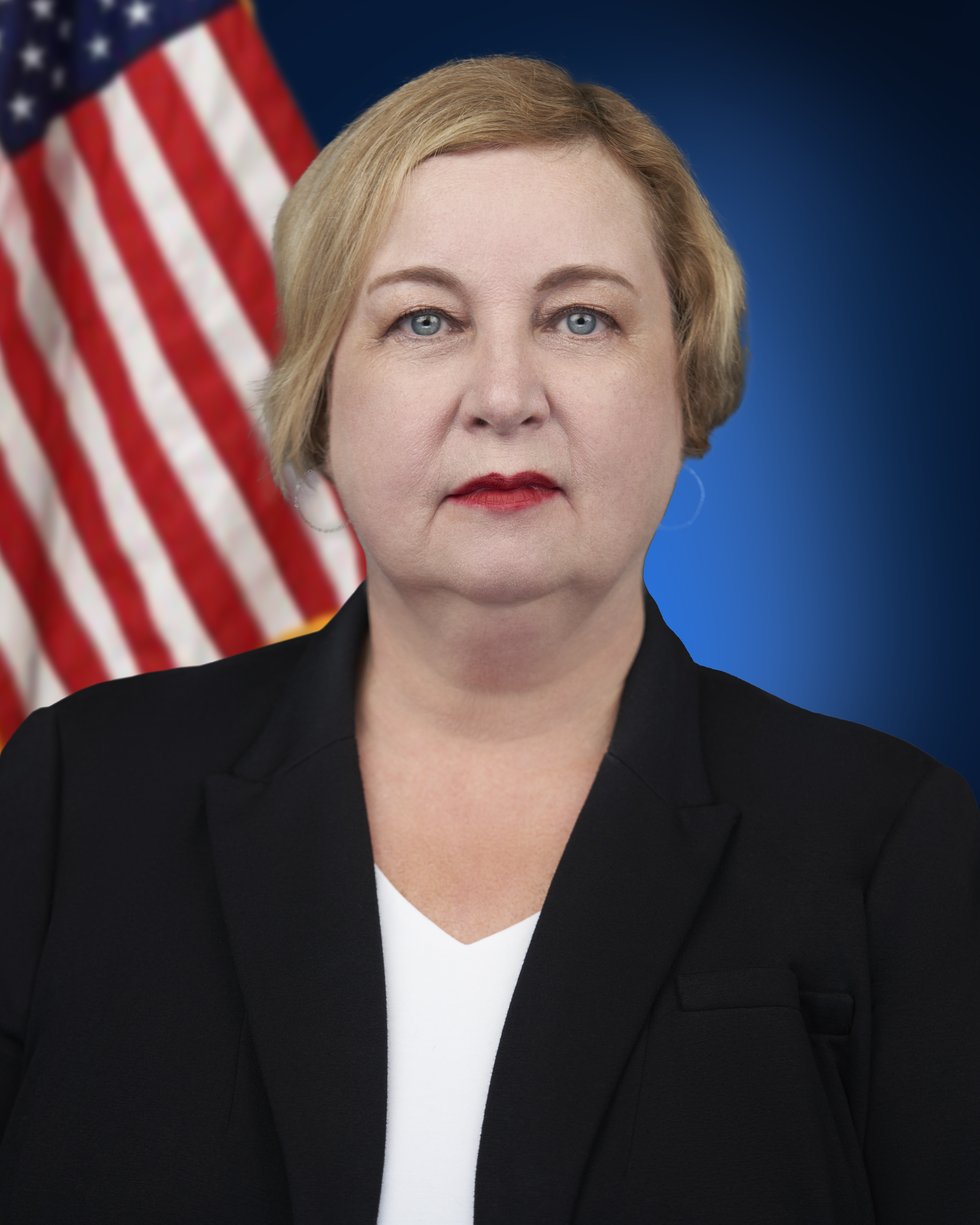 Commissioner Christy McCormick next to an American flag