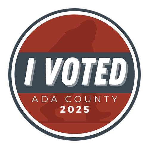 Circular sticker with white and black border, centered in blue trip in bold white text reads “I VOTED ADA County 2025”, behind in red background is a silhouette of a Big Foot creature. 