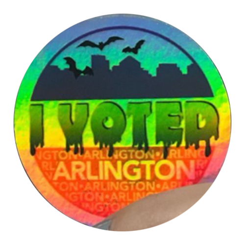 Round Halloween “I Voted” sticker with rainbow gradient, black skyline, bats overhead, dripping text, and “Arlington” below. 
