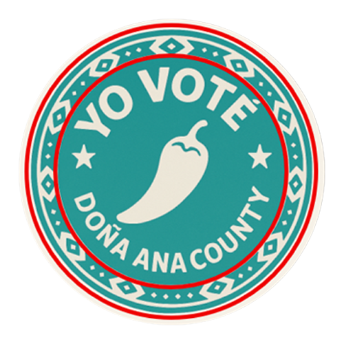 Circular tan, red, and green border with pattern, centered is a tan jalapeno with circular tan wrapped text reads “YO VOTE DONA ANA COUNTY”. 