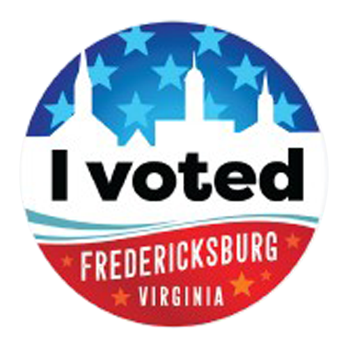 Circular sticker with blue stars and background, below in bold white text reads “I voted”, below in white text on red pattern reads “Fredericksburg, Virginia”. 